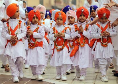 Niños sij desfilan durante una procesión para celebrar en la víspera del 548º aniversario del nacimiento del fundador del sijismo, Sri Guru Nanak Dev Ji, en Amristar (India).