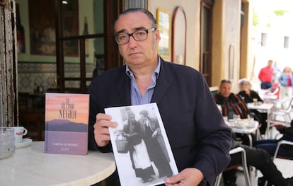 Joaquín García de Romeu sostiene una foto de ella junto a su libro en el bar Vicente de El Puerto de Santa María.