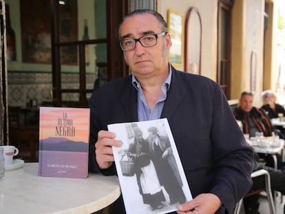 Joaquín García de Romeu sostiene una foto de ella junto a su libro en el bar Vicente de El Puerto de Santa María.