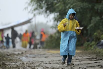 Un niño refugiado lleva un plato de comida en Berkasovo, Serbia.