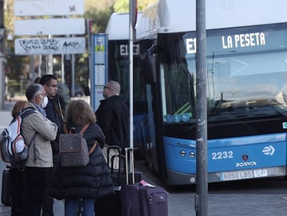 Varias personas esperaban el autobús en una parada de la EMT en Cibeles, en Madrid, en 2020.