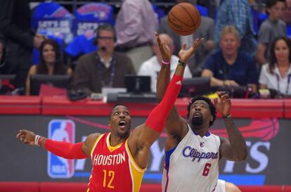 Dwight Howard y DeAndre Jordan saltan por el balón.