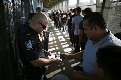 Oficiales fronterizos revisando las visas de los visitantes en la frontera de México-Estados Unidos