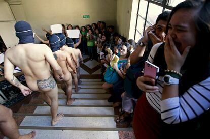 Estudiantes de la fraternidad Alfa Pi Omega bajan desnudos las escaleras durante la 'carrera de la oblación' en la Universidad de Manila (Filipinas).