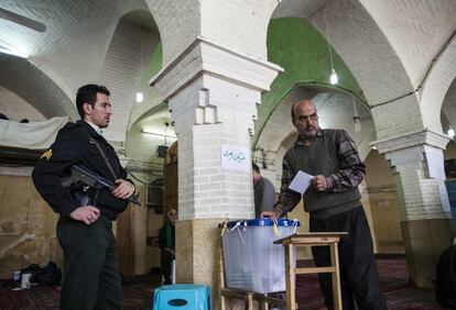 Un iraní deja su voto en una urna en un colegio electoral en la ciudad santa de Qom, a 130 kilómetros al sur de Teherán.