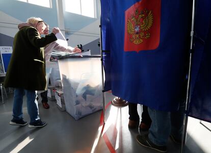 Una mujer deposita las papeletas de votación en un colegio electoral de San Petersburgo, este domingo.