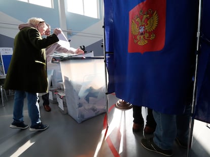 Una mujer deposita las papeletas de votación en un colegio electoral de San Petersburgo, este domingo.