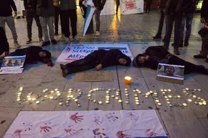 Niños sirios fingen estar muertos en el suelo al lado de las palabras 'War Crimes' ('Crímenes de Guerra') escrito con velas, durante una protesta en Salónica (Grecia), el 16 de diciembre de 2016.