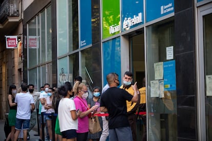 Personas con mascarilla, hacen cola en la Oficina de Treball de la Generalitat de Catalunya.