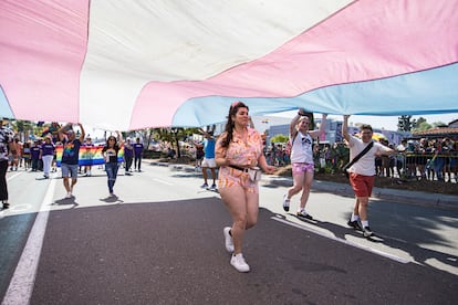 Asistentes al desfile del Orgullo ondean una bandera de la comunidad transgénero, en San Diego, California, en junio de 2023.