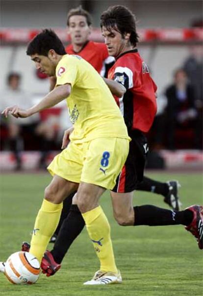 El argentino Juan Roman Riquelme, del Villarreal, lucha por un balón con el jugador del Mallorca Guillermo Pereyra.