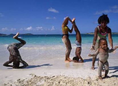 Niños y mayores juegan en una playa de la isla San Martín, en las Antillas francesas (Caribe).