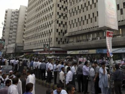 Varias personas permanecen en la calle después de la evacuación de varios edificios en Karachi (Pakistán) este martes.