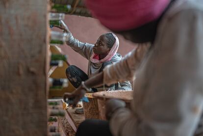 Rama y Kana limpian las botellas de cristal que se utilizarán posteriormente como ladrillos y a la vez claraboyas en construcciones desarrolladas con materiales reciclados y materias primas del entorno en Gandiol, Senegal.