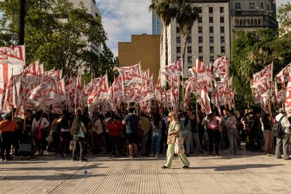 Una mujer camina detrás de un contingente de manifestantes.