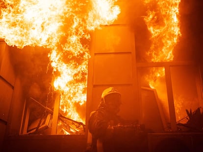 Un bombero junto a las llamas de un edificio atacado esta madrugada en Odesa.