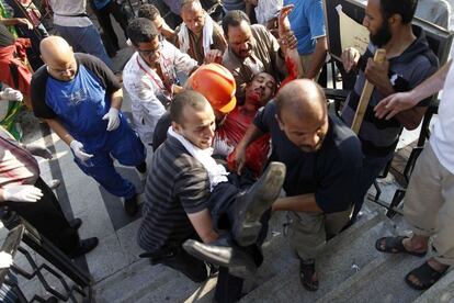 Un partidario del expresidente Mohamed Morsi es trasladado a un hospital de El Cairos tras el tiroteo de esta madrugada entre las fuerzas de seguridad y los partidarios de los Hermanos Musulmanes frente a la sede de la Guardia Presidencial de El Cairo, 8 de julio de 2013.