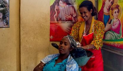 Berhan, ex apadrinada, lava el cabello de una clienta en su peluquería.