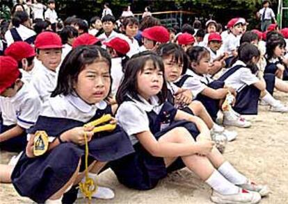 Niños de la escuela Ikeda (Osaka), ayer, asustados en el patio de su colegio tras el asalto en el que murieron ocho de sus compañeros.