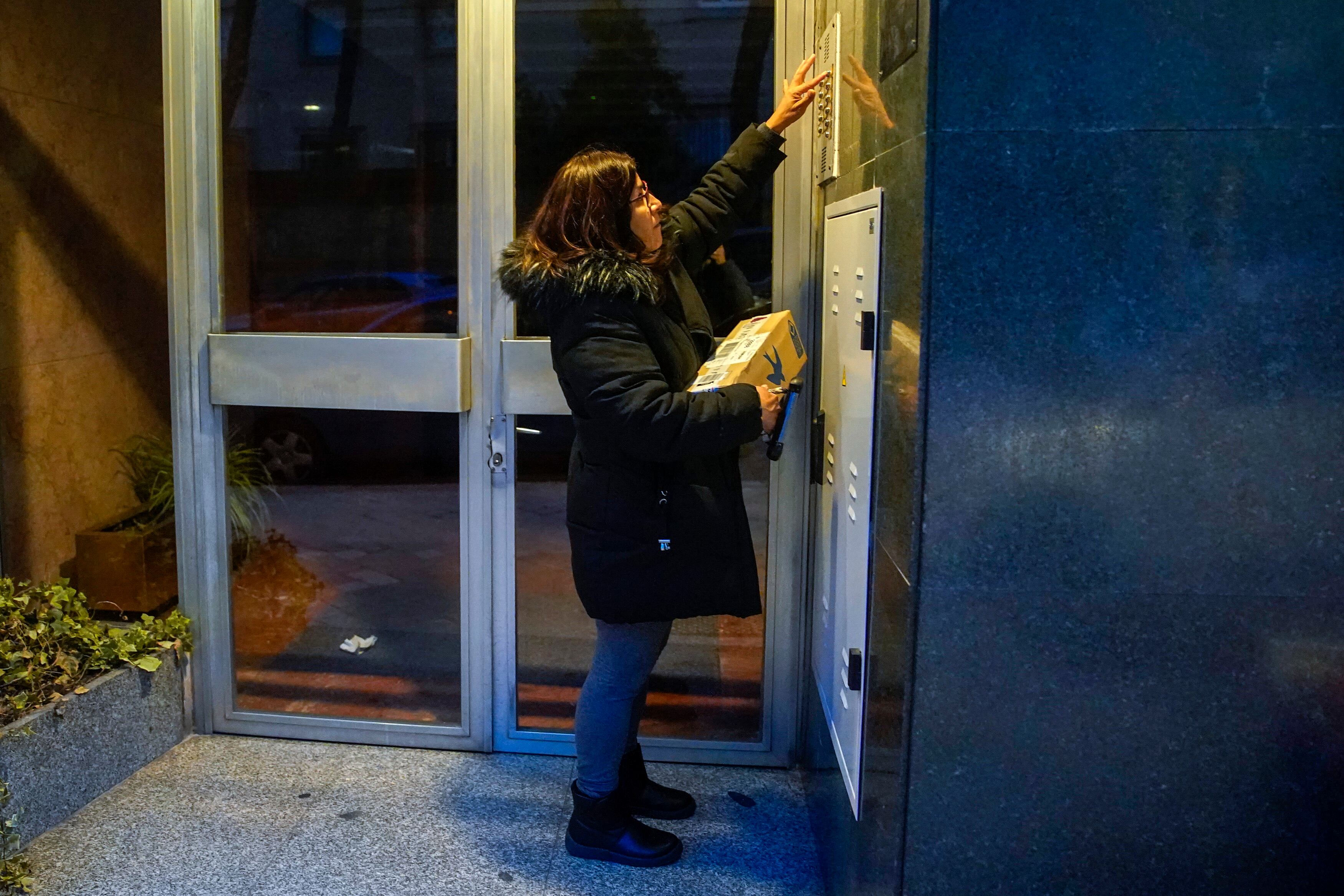 Mónica llama a un timbre para entregar un paquete en Madrid.