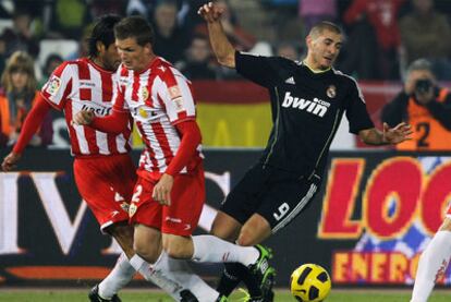 Bernardello y Jakobsen pelean por el balón con Benzema en el encuentro en Almería.