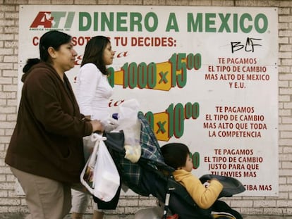 Varias personas pasan delante de un cartel de remesas en Chicago