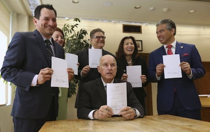 El gobernador de California, sentado, y los promotores de la reforma del sistema de fianzas, tras la firma de la ley, el martes.