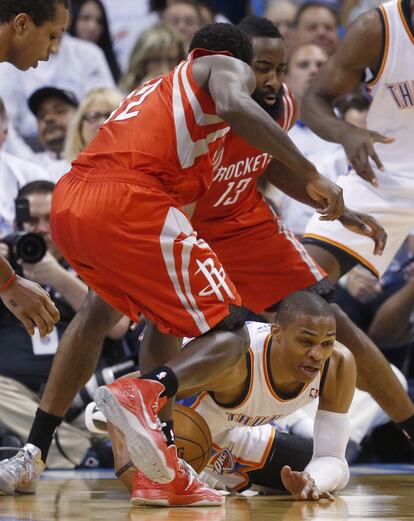 Patrick Beverly y James Harden, de los Houston Rockets, tratan de arrebatarle el balón a Westbrook