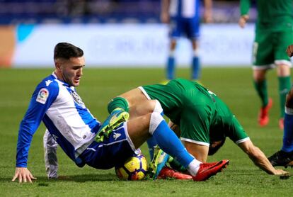 El deportivista Lucas Pérez disputa la pelota a un defensor del Leganés.