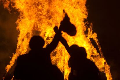 Dos jóvenes celebran la noche de San Juan en la playa de Riazor de A Coruña.