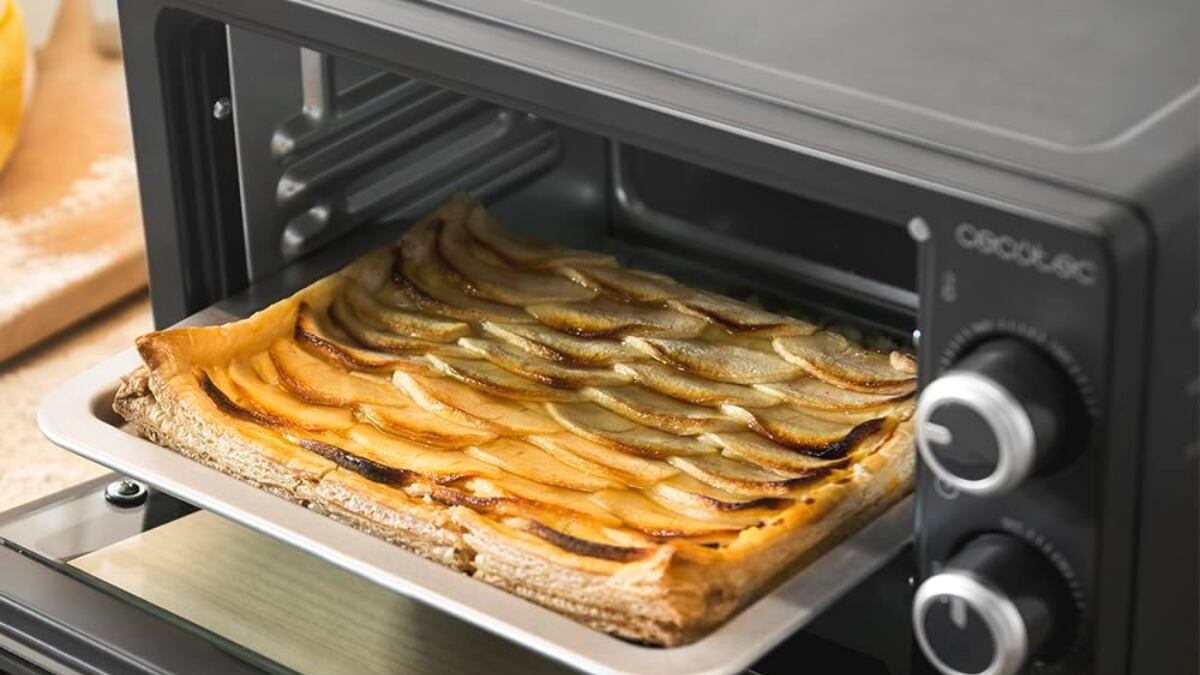 Horno de sobremesa con bandeja para hornear, parrilla y una asa con pinzas.