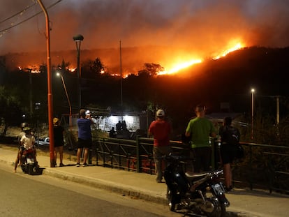 Personas observan el incendio forestal que ha forzado la evacuación de residentes de Villa Carlos Paz, en Córdoba, Argentina.