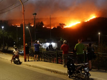 Personas observan el incendio forestal que ha forzado la evacuación de residentes de Villa Carlos Paz, en Córdoba, Argentina.