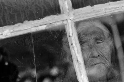 Una anciana observa desde una ventana en Tasiusaq, Groenlandia, en 1990.<br><br><i>Así, su obra tiene tanto de asombro estético como de afán por documentar una tragedia y llamar la atención para que se le ponga freno. Hace unos 30 años en Groenlandia, un buen día, un viejo cazador le dijo al fotógrafo: “Aquí está pasando algo raro. El hielo está enfermo”.</i></br>