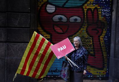 Una dona que participa a la manifestació en favor de la Constitució a Barcelona amb una bandera de Catalunya i el cartell "PAU".