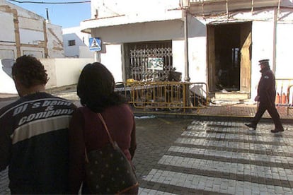 Unos vecinos de Cartaya, ayer, ante la casa incendiada en la que murió una anciana.