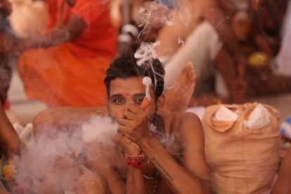 Un hombre hindú fuma mientras espera para registrarse en el peregrinaje anual al Santuario de la cueva de Amarnath, en Jammu (India).