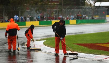 Operarios del circuito quitan agua de la pista.