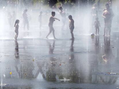 Unos niños juegan con el agua en una de las fuentes de Madrid Río.