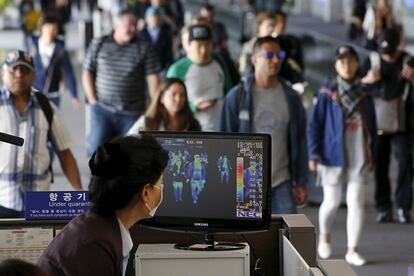 Pasajeros del aeropuerto Internacional de Incheon (Corea del Sur) pasan por un control de cámaras térmicas. A pesar de que 25 personas se han contagiado en Corea del Sur con el Síndrome Respiratorio de Oriente Medio (MERS-CoV) o nuevo coronavirus, la Organización Mundial de la Salud (OMS) dice que aún no se puede hablar de que exista una trasmisión sostenida del virus de humano a humano.