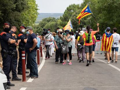 Agentes de los Mossos d'Esquadra observan a los manifestantes que protestan contra la visita del Rey en el monasterio de Santa María de Poblet (Tarragona).