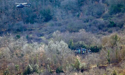 A la derecha, el helicóptero accidentado en la Sierra de Cameros en La Rioja, este jueves.