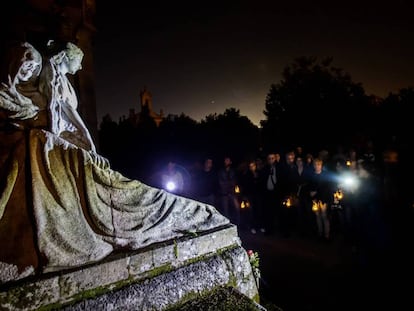 Participantes en una visita nocturna contemplan una tumba labrada por el escultor Francisco Asorey en el cementerio de Vigo.