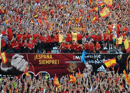 Miles de aficionados animan en la plaza de Colón de Madrid en una explosión de color rojo durante el desfile de la selección española de fútbol tras la victoria en la Eurocopa de 2008.