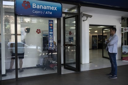 Un cliente hace fila para usar un cajero automático en una sucursal bancaria de Banamex, en Ciudad de México.