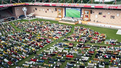 Aficionados del Unión Berlín en el estadio viendo el fútbol televisado en sofás.