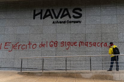 Un manifestante escribe un mensaje de protesta sobre la fachada de un edificio durante la manifestación de este jueves.