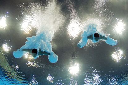 Los chinos Yuan Cao y Yanquan Zhang se sumergen en la piscina tras realizar su salto.