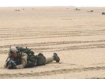 Un soldado estadounidense con la equipación de combate permanece cuerpo a tierra en una zona de maniobras cercana a la frontera con Kuwait.
