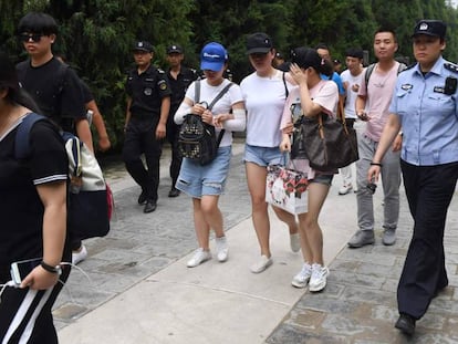 La policía escolta en Pekín a varios manifestantes afectados por las pérdidas de las plataformas P2P. 